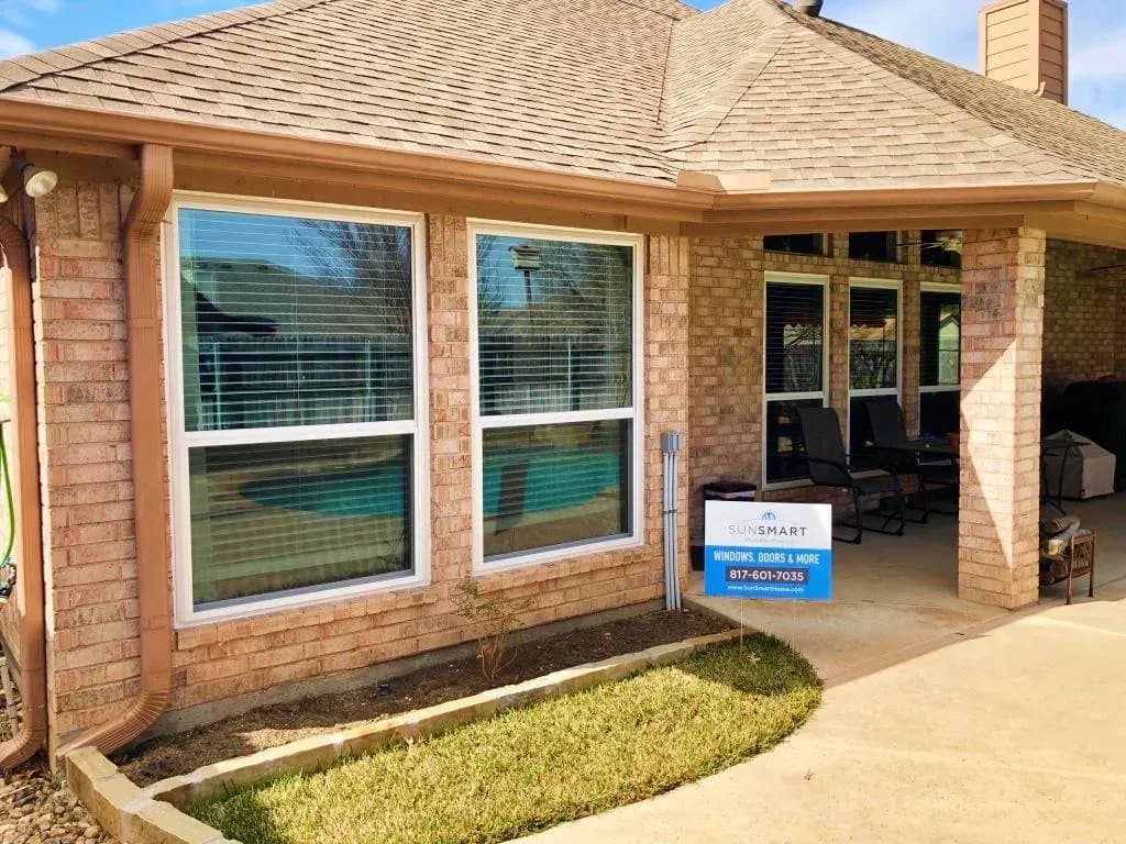 SunSmart installer fitting a replacement window from inside a DFW home